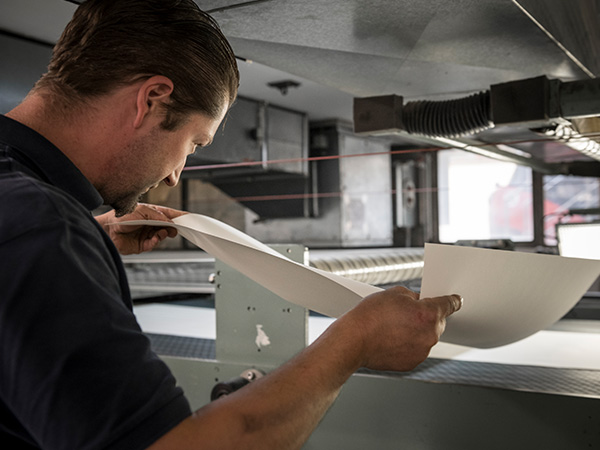 Man checking the quality of paper during the production