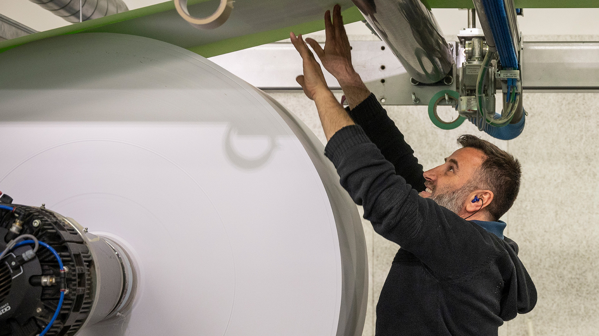 Man checking a paper roll during the production