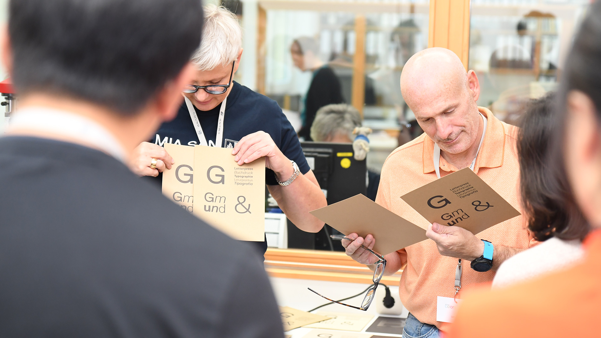 Woman presenting printed samples and a man is checking samples