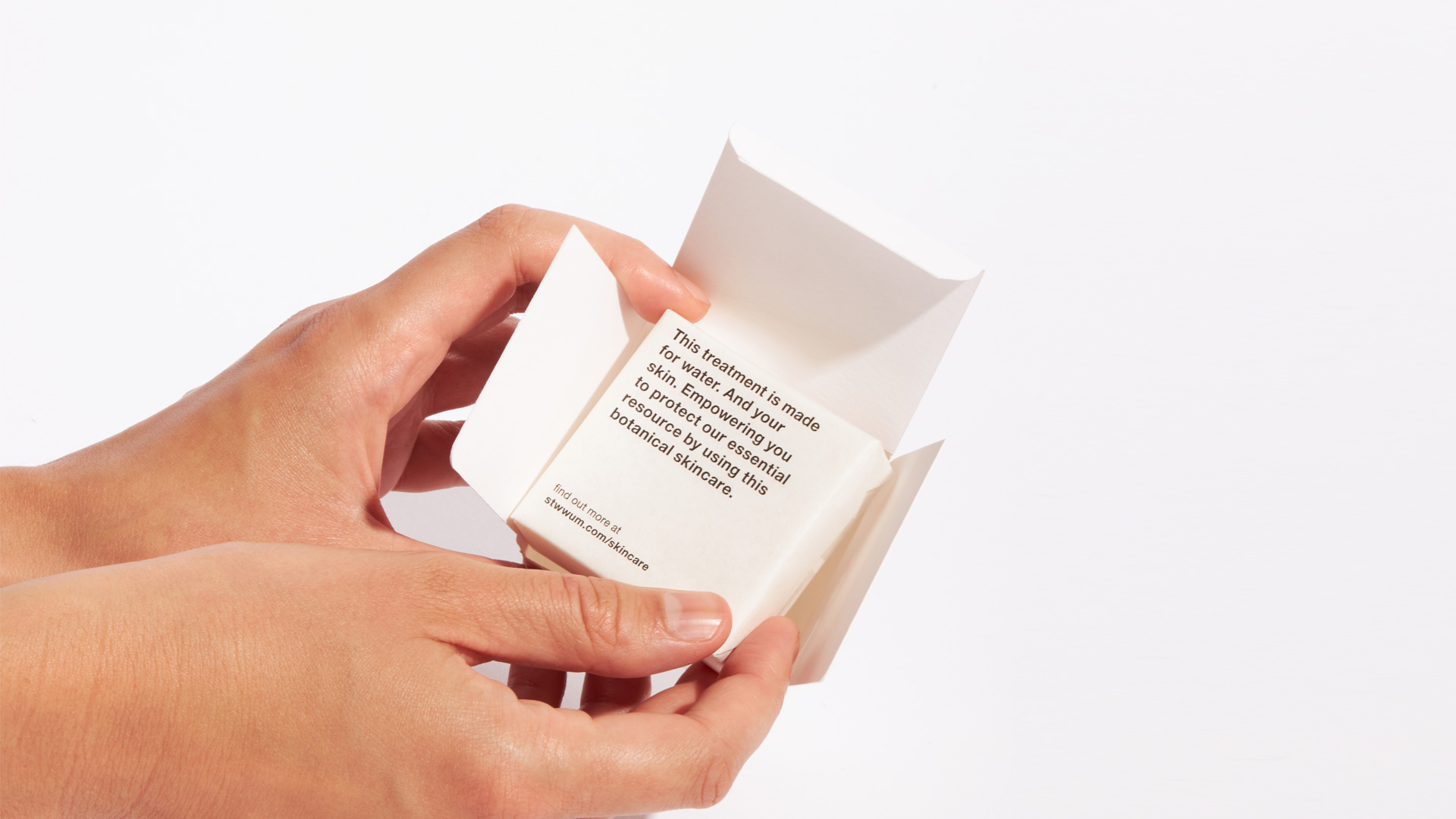 Hands holding a Stop the water while using me folding box out of paper