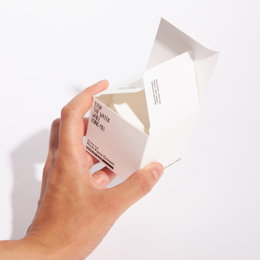 Hand holding a Stop the water while using me folded box