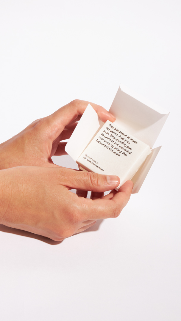 Hände halten eine nachhaltige Stop the water while using me Papierfaltschachtel mit Seife